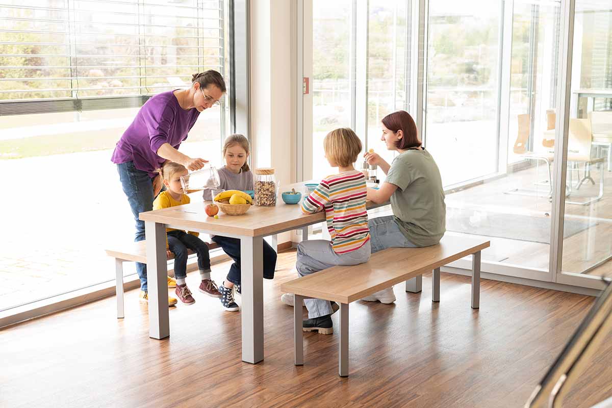 essBar Tisch und Bänke mit Familie mit Kindern beim Essen