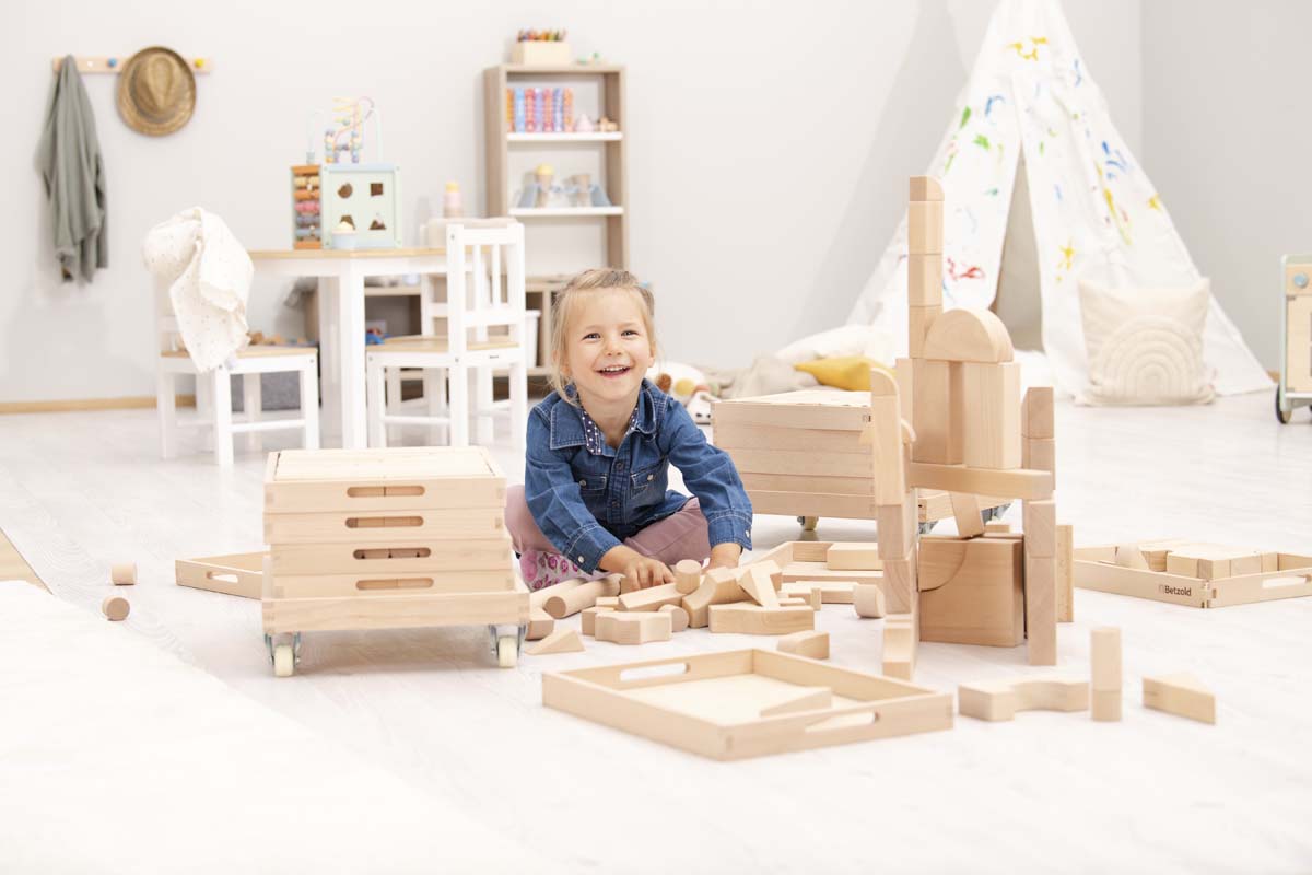 Betzold Bausteinwagen Gesamtansicht mit 6 Fächern, Kindersitzgruppe im Hintergrund
