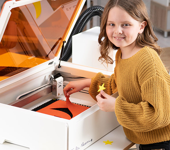 Kind holt ihr fertiges Projekt aus dem Lasercutter