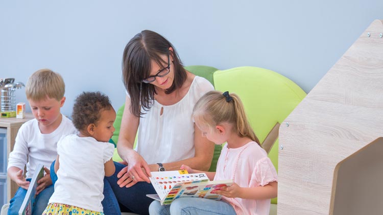 Kinder lesen neben educasa Spielhaus von Betzold