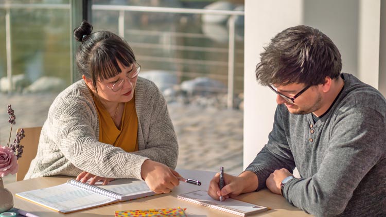 Erzieher und Elternteil im Gespräch an einem Tisch