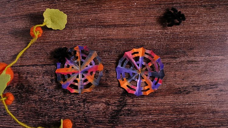 Aus Filterpapier, Wasserfarben und Schere wird mit ein wenig Trocknungszeit schnell ein buntes Spinnennetz.