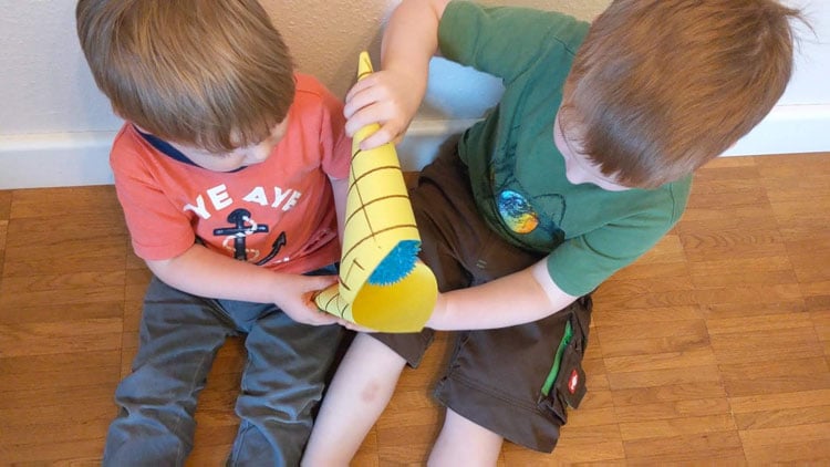 Zwei Kinder reichen einen Ball in einer Waffel weiter