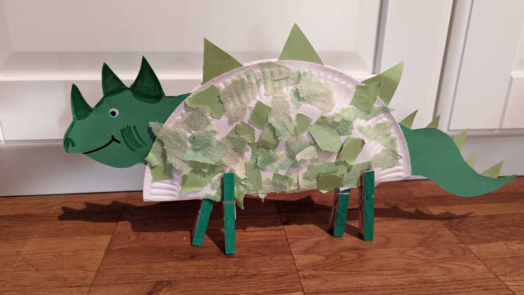 Dinosaurier aus einem Pappteller und Papprollen gebastelt.