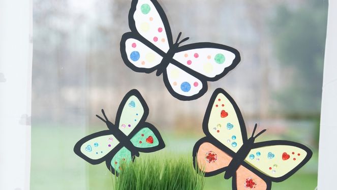 Fensterschmetterlinge Drei verschieden grosse Schmetterlinge die als Dekoration an ein Fenster geklebt sind