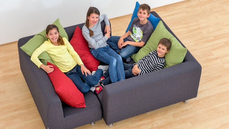 Schüler liegen aufSofalandschaft