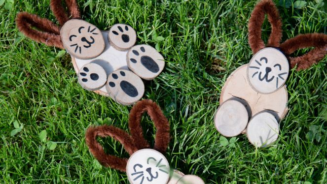 Holz-Hasen gebastelte Hasen aus Holzscheiben im Gras liegend