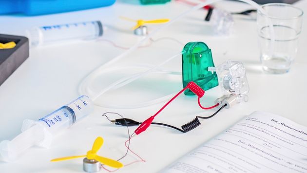 Alternative Energien Koffer Versuchsaufbau eines Dynamos auf einem Tisch mit Material aus dem Experimentierkoffer