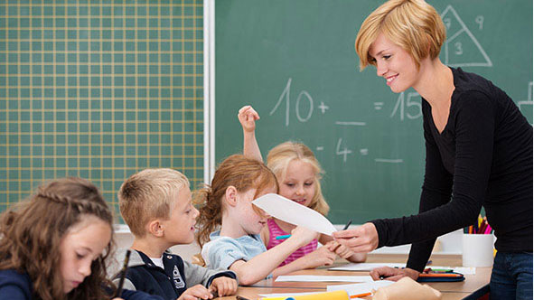 Lehrerin teilt Arbeiten aus