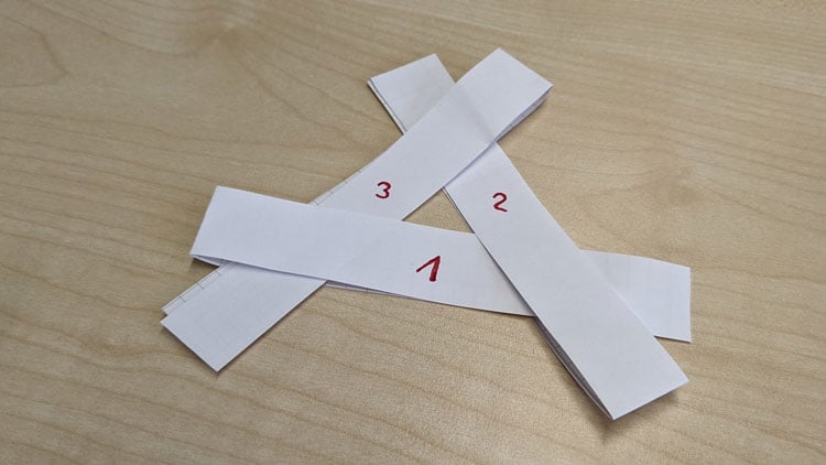 3 Papierstreifen mittig gefaltet und ineinandergeschoben - so entsteht ein Mini-Windrad.