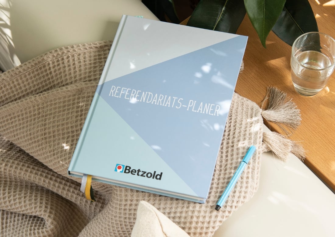 Referendariatsplaner mit Cover aus diversen Blautönen auf einem Sofa liegend