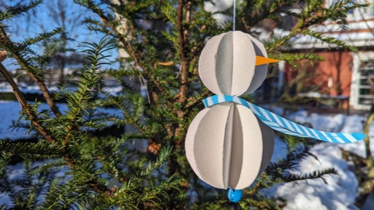 Aus Tonpapier entsteht schnell eine winterliche Schneemann-Dekoration.
