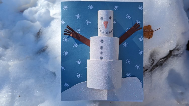 Winterliche Grusskarte mit einem Schneemann aus Glitzer-Tonpapier.