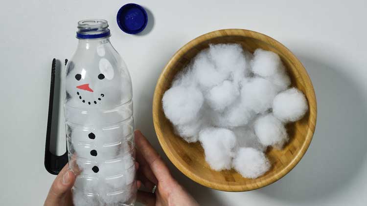 Mit Watte und einer Flasche mit grosser Öffnung lässt sich schnell ein Schneemann gestalten.