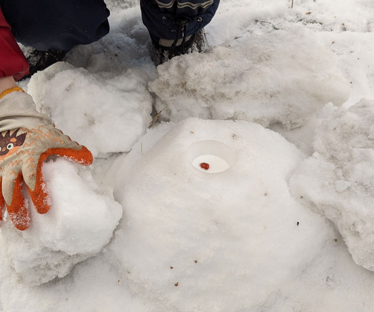 Kinder bauen Schneevulkan