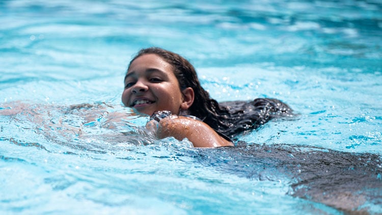 Mädchen schwimmt in Schwimmbad