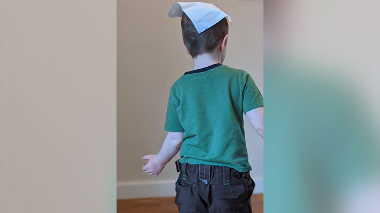Junge tanzt mit Taschentuch auf dem Kopf