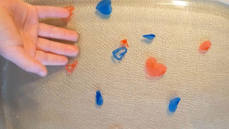 Mit Betzold Boardmarkern gemalte Herzen auf Glas, die im Wasser schwimmen.