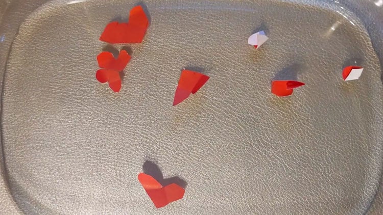Schwimmende Papierherzen in Wasser