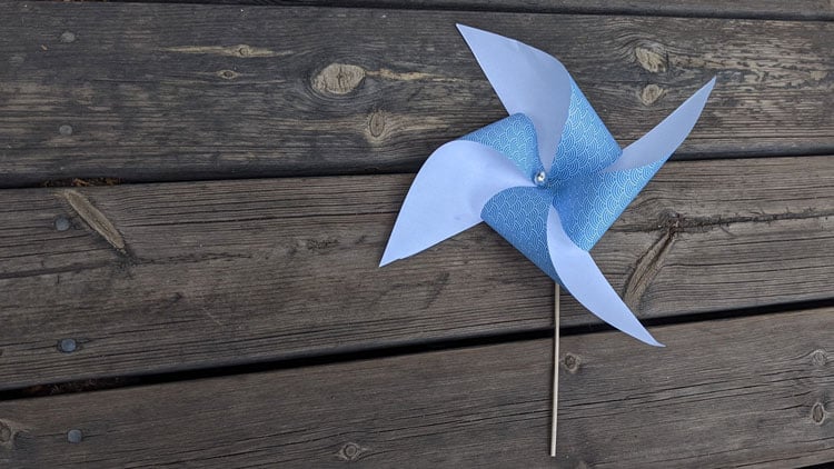 Einfaches Windrad aus einem quadratischen Stück Papier, Draht und einem Holzspiess.