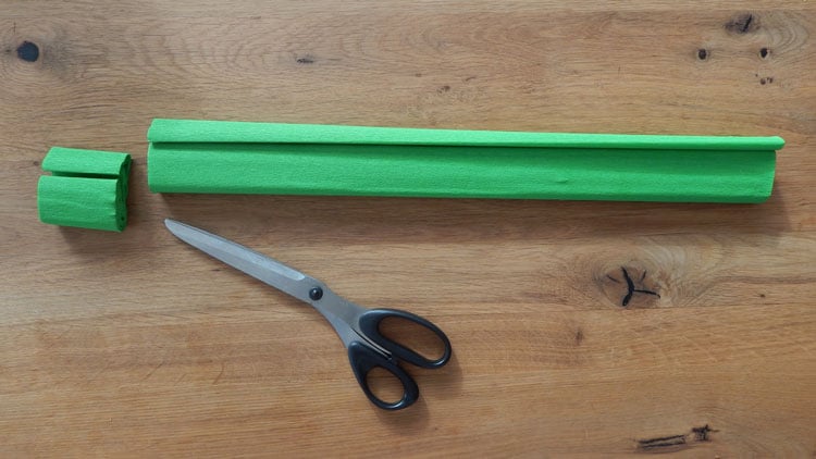 Grünes Bastelpapier wird in Rollen geschnitten